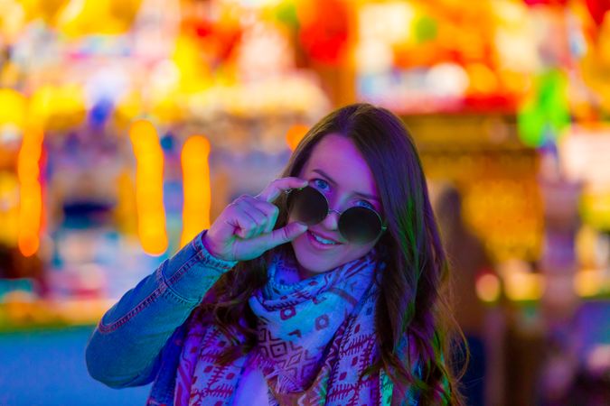 Stylish young woman near illumination on street