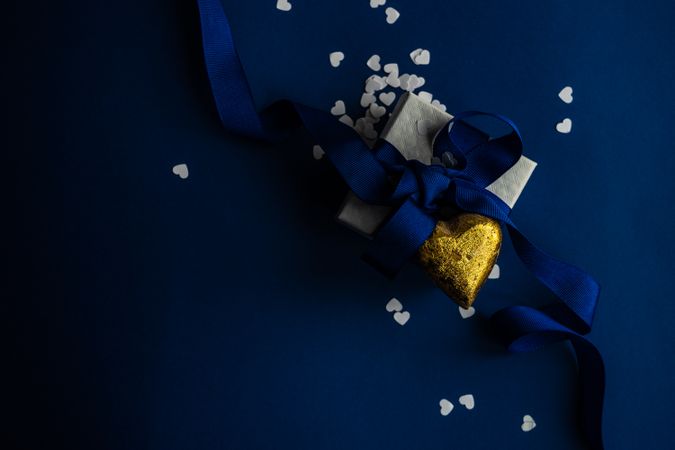 Top view of blue Valentine day concept with giftbox and golden heart decoration
