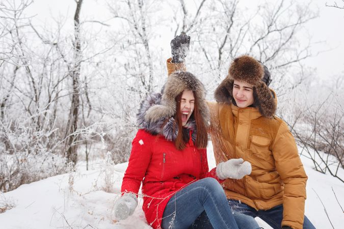 Cute teenage couple playing in the snow