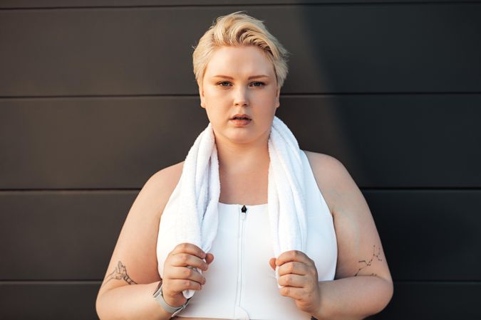 Blonde woman in workout gear with towel around her neck