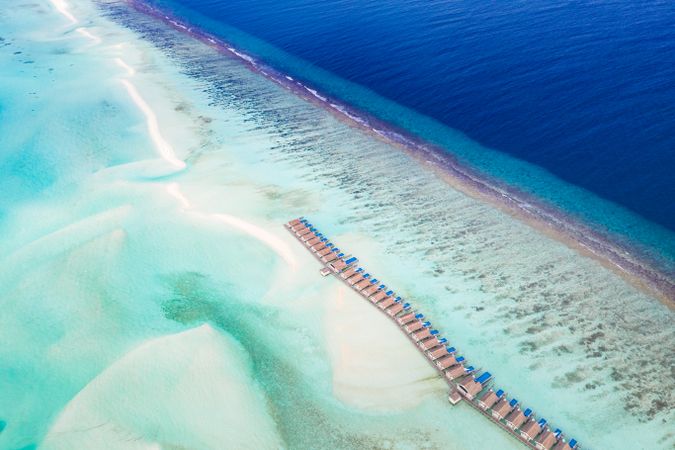 Drone shot of overwater bungalows in the sea