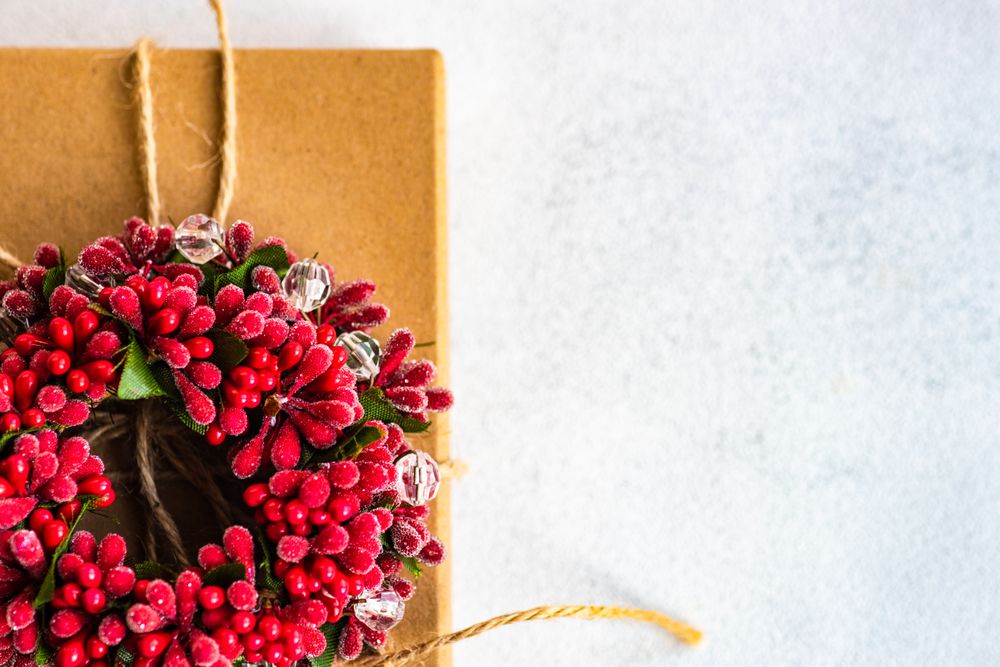 Holiday gift with red holly wreath and string
