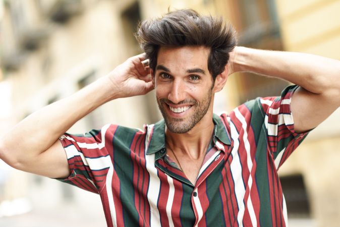 Portrait of smiling dark haired man standing outside