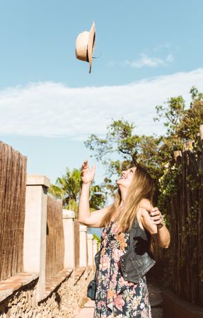 Happy woman throwing hat up