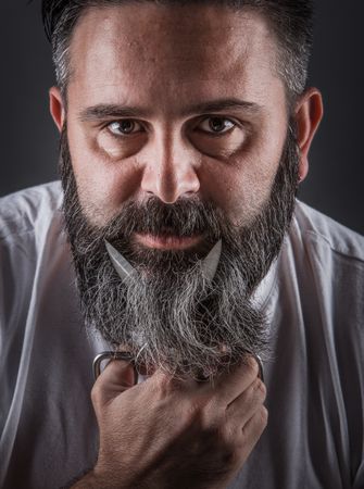 Expressive barber cutting beard