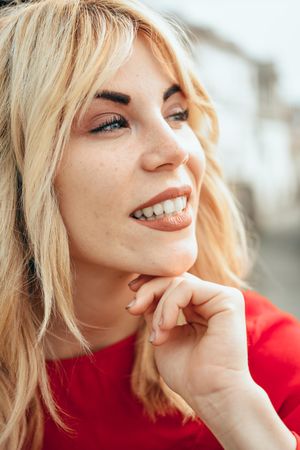 Blonde woman happy with head resting on her hand