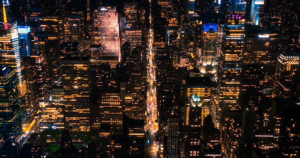 Scenic Aerial New York City View of Downtown Manhattan Architecture. High Angle Night Photo of the Business District from a Helicopter. Cityscape with Office Buildings and Busy Traffic on Streets