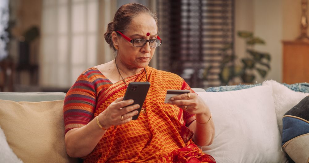 Older Indian Woman Using Smartphone and Credit Card