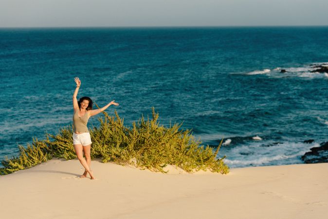 Active woman in white shorts walking sandy beach