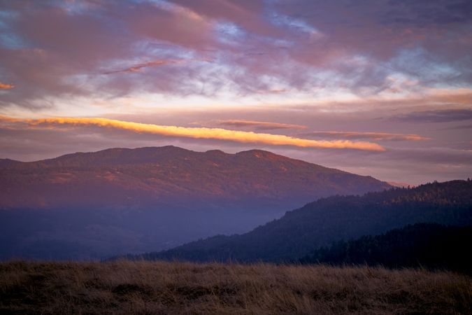 Rolling mountains under a purple hued sunset