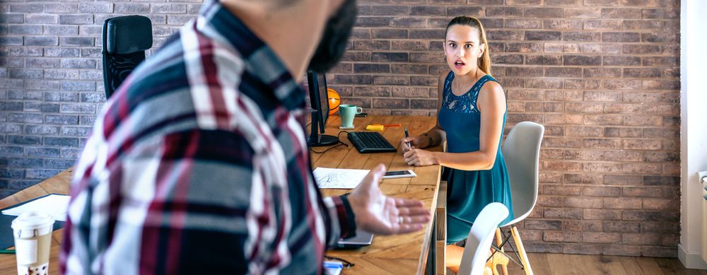 Woman shocked by what her coworker is telling