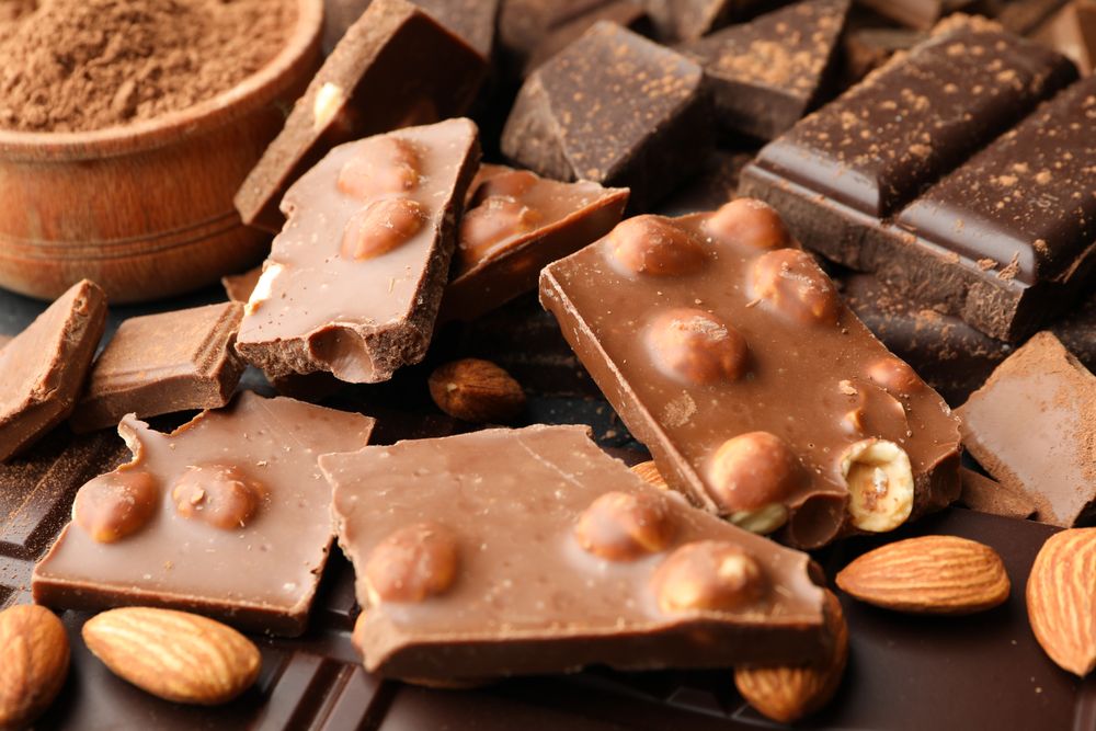 Chocolate, melted chocolate and almond on dark background