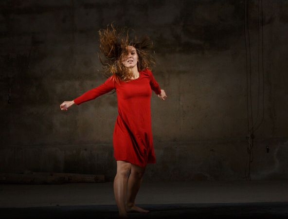 Young woman dancing in darkness