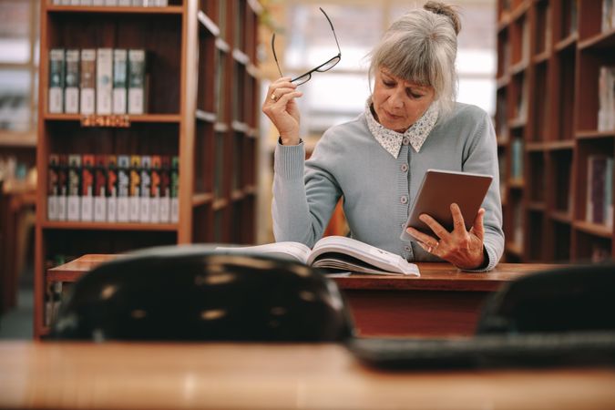Woman sitting in a library reading a book