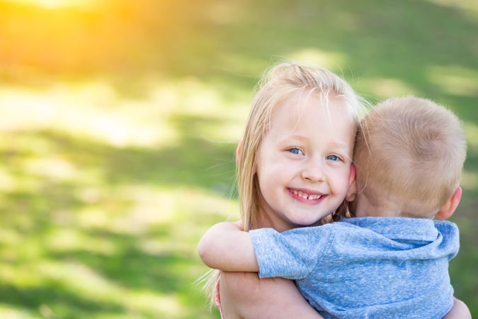Young Brother and Sister Hugging At The Park