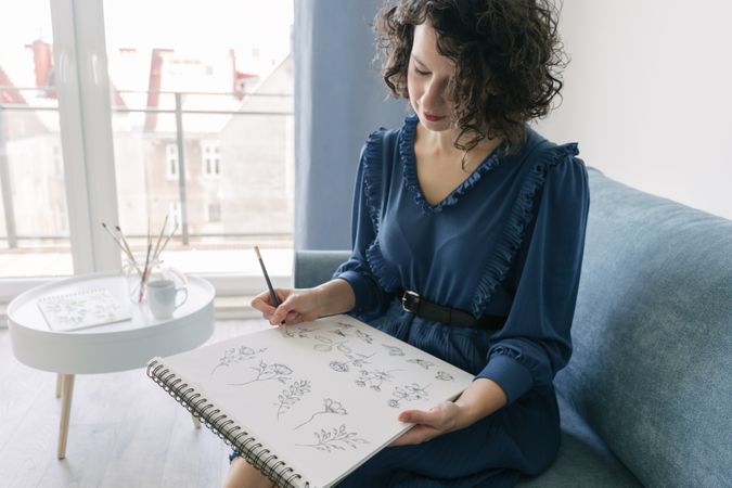 Woman artist drawing at sofa
