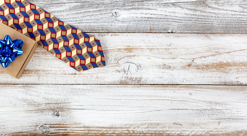 Happy Fathers Day concept with simple gift box and dress tie on rustic wood with plenty of copy space