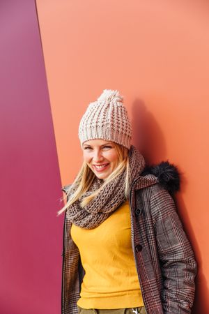 Blonde woman leaning on a colorful wall