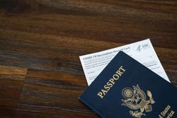 Cropped shot of CDC vaccination card under US passport