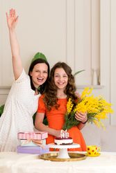 Girl and woman raising arms in celebration birthday