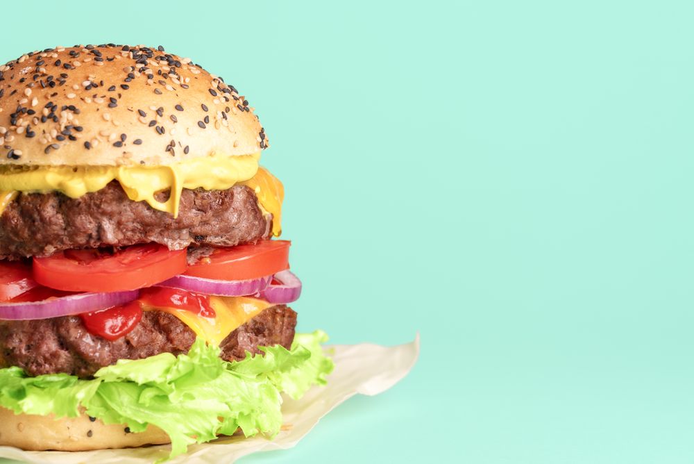 Hamburger side view close-up isolated on a green background