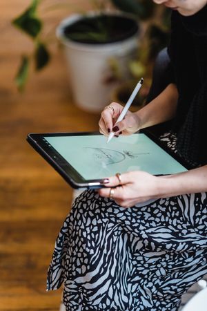 Cropped image of woman drawing on computer tablet