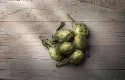 Green artichoke on wooden table