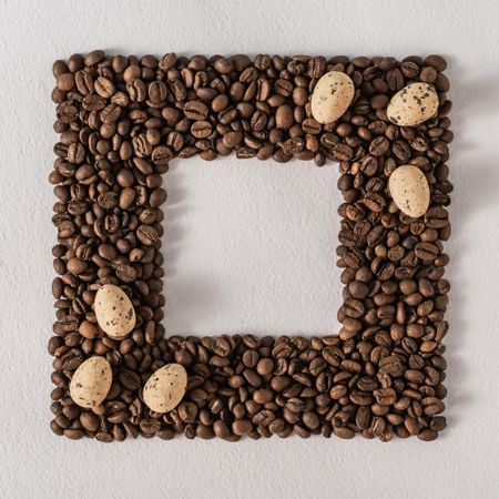 Frame of coffee beans with scattered eggs