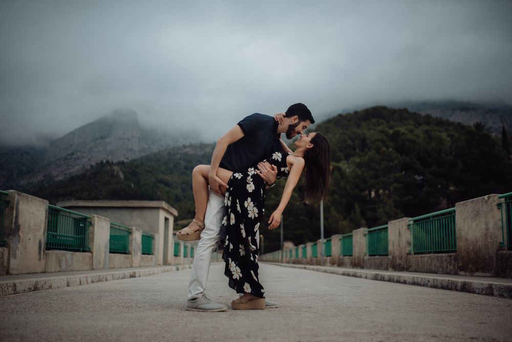 Sensual couple embracing while on rural bridge