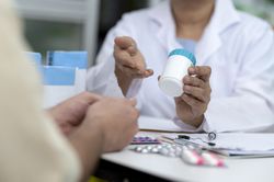 Indian Asian elderly female pharmacist advises patient