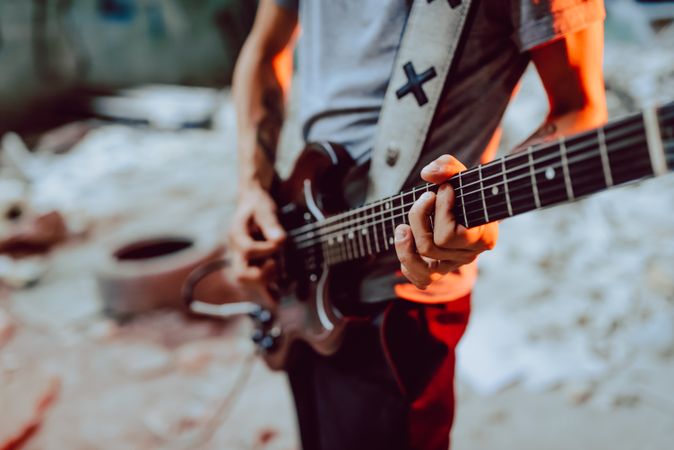 Man clamping strings on guitar neck