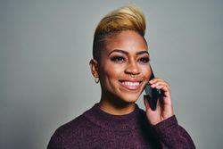 Smiling Black woman speaking on a cell phone