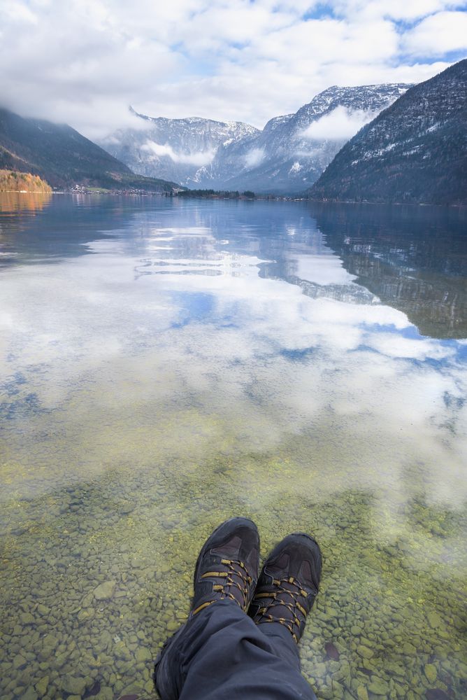 POV of man’s legs relaxing over Alpoine lake