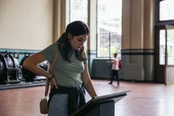 A woman stands reading an informational sign in a museum
