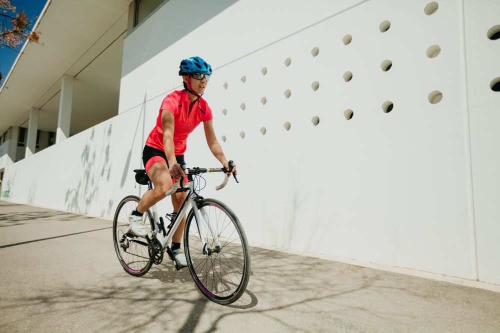 Sportswoman riding bicycle on street