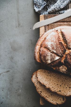 Freshly baked sourdough bread loaf, sliced, vertical composition, copy space