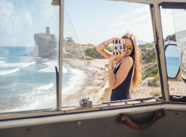 Woman taking photo at rocky coast