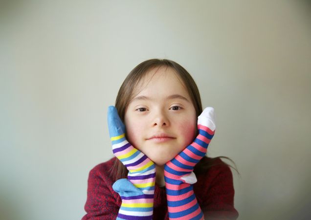 Silly girl playing with two different socks on her hands