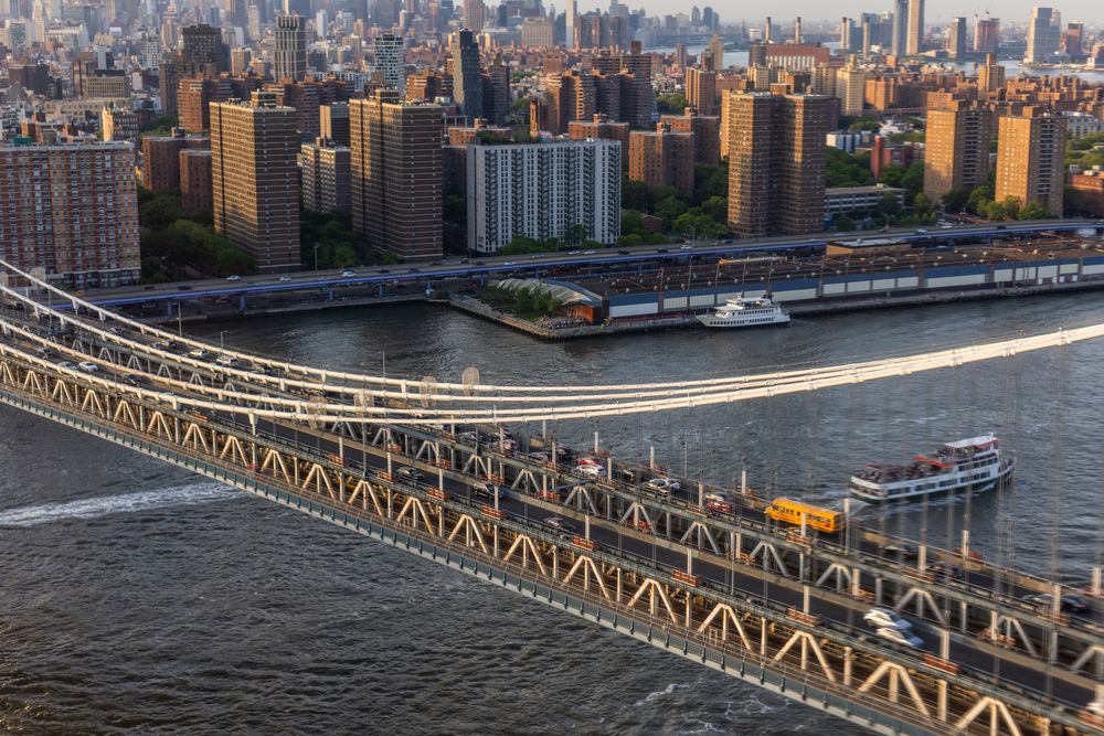 Aerial Cinematic Drone Scene Near a Bridge with Lower Manhattan Skyscrapers Cityscape. Beautiful Evening Sun Shining with Warm Sunset Light. Shot of a Suspension Bridge Architecture