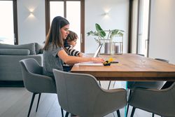 Woman working on laptop in kitchen