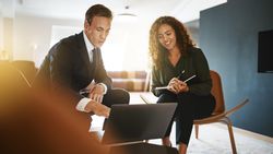 Man and woman working on a presentation together over a laptop