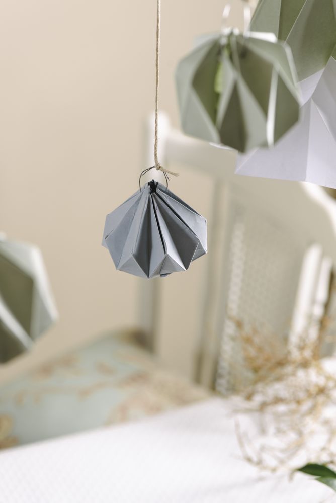 Christmas decor interior origami paper, ornament hanging on pastel threads