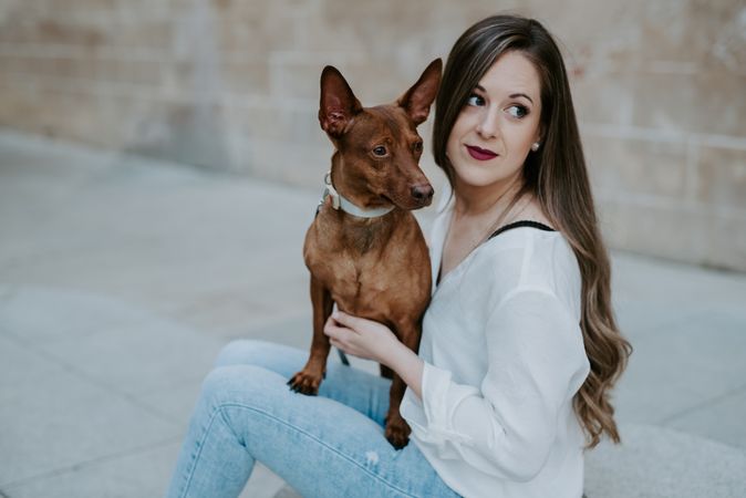 Woman with purebred dog on stone porch