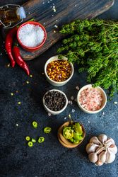 Variety of seasoning and herbs on dark counter