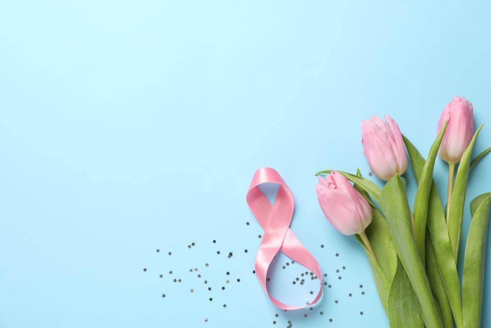 8 made of ribbon and pink tulips on blue background, space for text