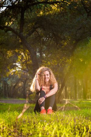 Happy woman sitting on sunny lawn