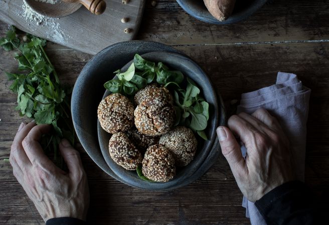 Person rolling in breadcrumbs sweet potatoes