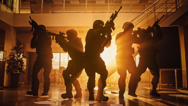 Soldiers with Rifles Move Forwards and Cover Surroundings. Shot with Yellow Warm Filter.