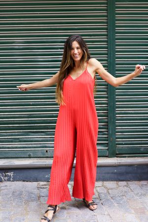 A Stylish Woman is spotted on an Urban Street wearing a Vibrant Red Jumpsuit that stands out