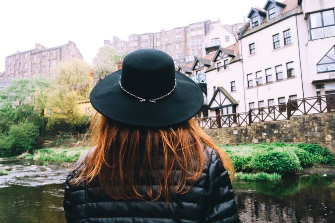 Woman contemplating city aged stone buildings